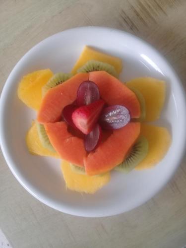 a white plate with fruit on a table at B&B Sombre di Kabana in Willemstad