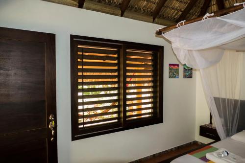 a bedroom with a window and a bed with a curtain at Cabañas Amaia in Mazunte
