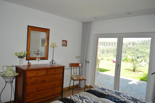 a bedroom with a bed and a dresser and a mirror at AL Ribeiro in Póvoa de Lanhoso