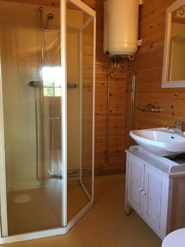 y baño con ducha y lavamanos. en Norrfällsvikens Camping, Stugby & Marina en Mjällom