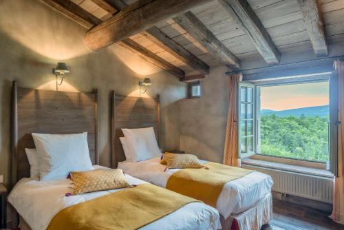 a bedroom with two beds and a large window at Domaine du Roc in Saou