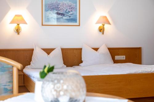 a hotel room with two beds and a table at Gasthof Metzgerei Neumeyer in Kipfenberg