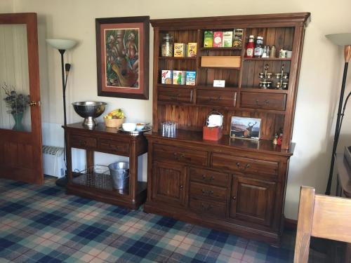 a room with a large wooden cabinet and a table at Eriskay B&B and Aviemore Glamping in Aviemore