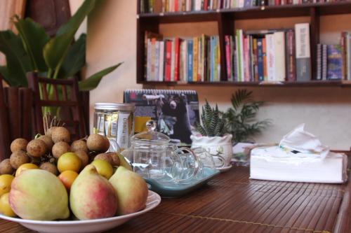 a wooden table with two bowls of fruit on it at Chicken's house- Đường Lâm Homestay in Hanoi