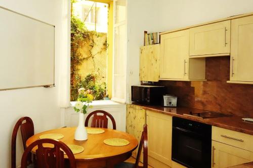 une cuisine avec une table avec un vase de fleurs dessus dans l'établissement CANNES - À DEUX PAS DU PALAIS DES FESTIVALS, à Cannes