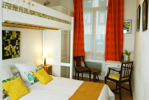 une chambre avec un lit et deux chaises et une fenêtre dans l'établissement CANNES - À DEUX PAS DU PALAIS DES FESTIVALS, à Cannes