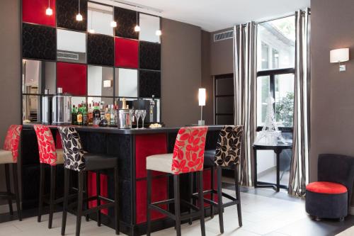 a bar with red and black bar stools at Hotel Eiffel Seine in Paris