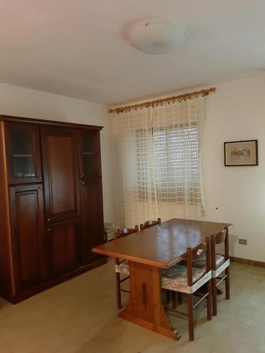 a dining room with a wooden table and chairs at Isola Rossa Appartamenti Standard in Isola Rossa