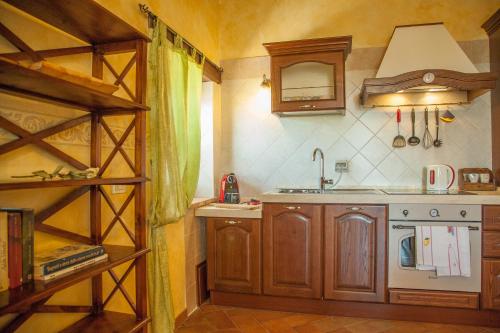 a kitchen with wooden cabinets and a sink in a room at Agriturismo Bio Tra Cielo e Terra in Grutti