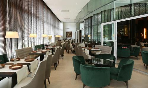 a restaurant with tables and chairs and windows at Hotel Cadoro São Paulo in Sao Paulo