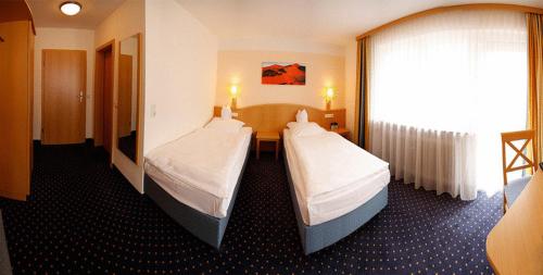 ケルクハイムにあるHotel-Restaurant Zum Goldenen Löwenのベッド2台と窓が備わるホテルルームです。