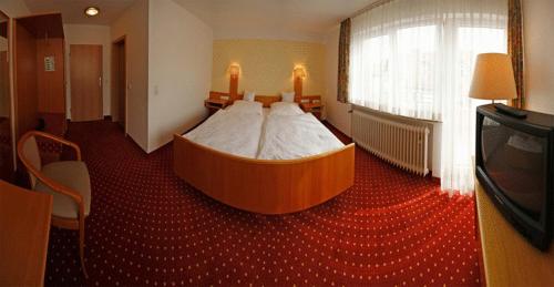 ein Schlafzimmer mit einem großen Bett in der Mitte in der Unterkunft Hotel-Restaurant Zum Goldenen Löwen in Kelkheim