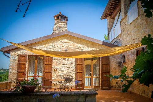 a stone house with a yellow hammock in front of it at Agriturismo Bio Tra Cielo e Terra in Grutti