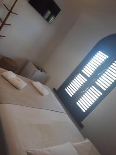 a room with a bed with a sign on it at Pousada Igrejinha dos Carneiros in Tamandaré