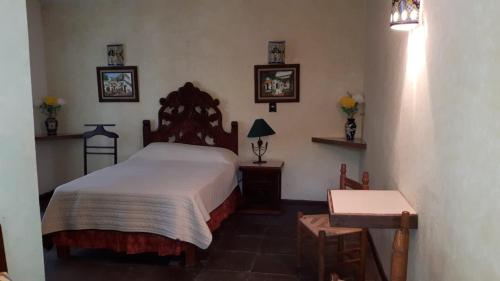 a bedroom with a large bed and a table at Hotel No Que No in Tepexi del Río