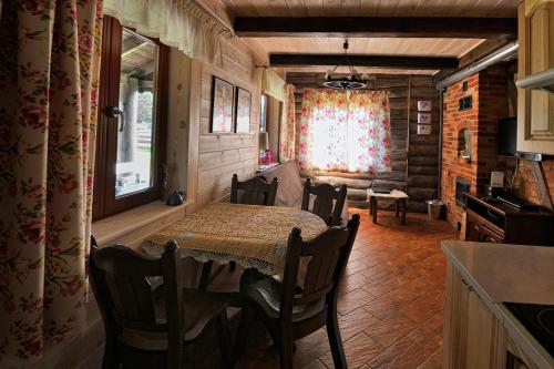 a dining room with a table and chairs and a window at Mazury-dom in Świętajno