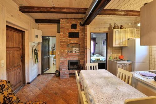 a kitchen with a table and a brick fireplace at Mazury-dom in Świętajno