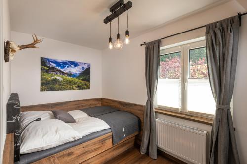 um quarto com uma cama e uma janela em Das Talblick - Appartments em Sankt Johann im Pongau