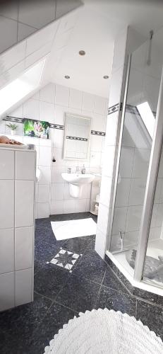 a white bathroom with a sink and a shower at Casa Mediterrana in Erkrath