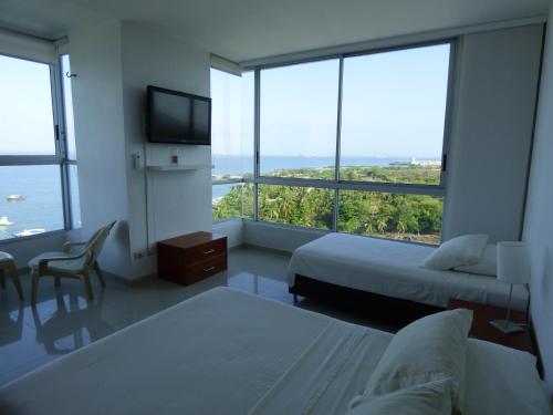 a hotel room with two beds and a television at Costa Azul Suites 906 in Santa Marta
