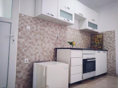 a kitchen with white appliances and a brick wall at Hostel Omega in Banja Luka