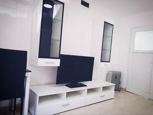 monitor komputerowy na białym biurku w pokoju w obiekcie Hostel Omega w mieście Banja Luka