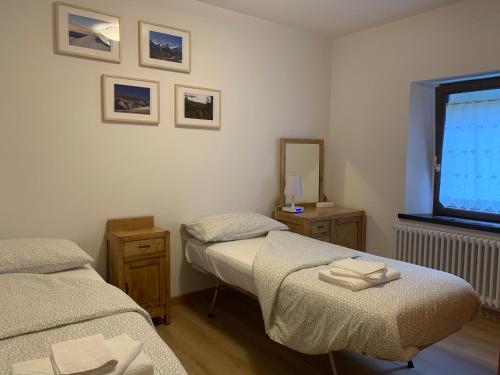 two twin beds in a room with a window at alla curva del Pagliai in Abetone
