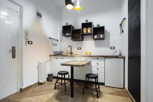 a small kitchen with a table and two stools at Apartment Korzo in Novi Sad