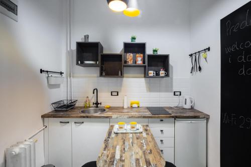 a kitchen with a sink and a wooden table at Apartment Korzo in Novi Sad