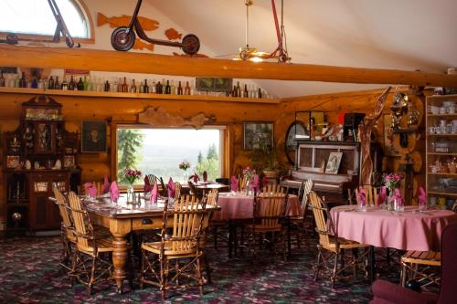 a dining room with tables and chairs with pink napkins at A Taste of Alaska Lodge in Fairbanks