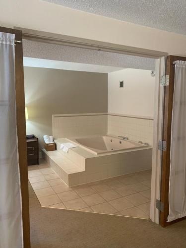 a bathroom with a large tub in a room at Ramada by Wyndham Marquette in Marquette