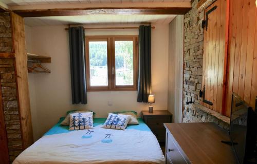 een kleine slaapkamer met een bed en een raam bij Chalet avec jardin proche piste in Les Deux Alpes