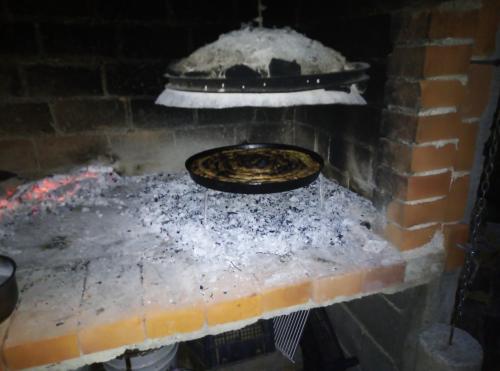 a pizza is cooking in a brick oven at Via Dinarica GuestHouse in Jablanica