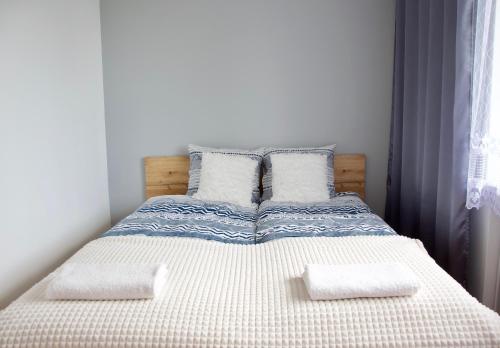 een slaapkamer met een bed met 2 kussens erop bij Apartamenty ZORZA in Krakau