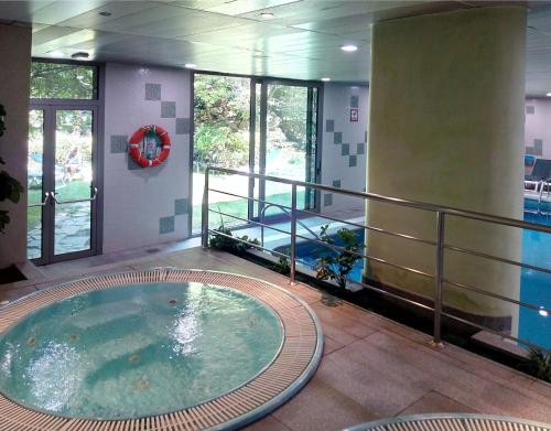 uma piscina com uma banheira de hidromassagem num edifício em Hotel Guillem & Spa em Encamp