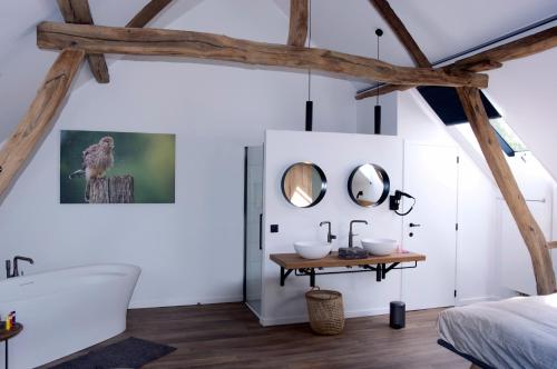a bathroom with a white tub and a sink at De Bonderbei in Wellen