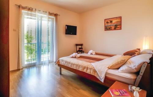a bedroom with a large bed and a large window at VILLA BEST in Bast
