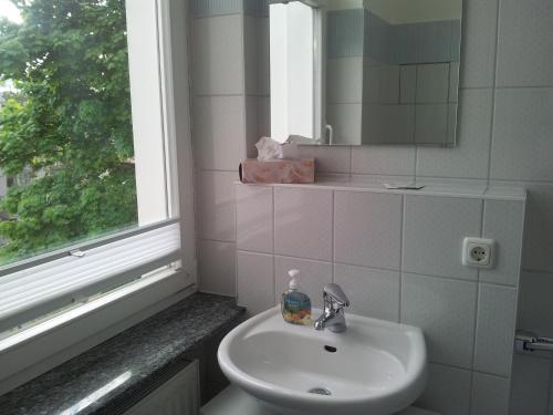 baño con lavabo, espejo y ventana en Villa Germania Südbalkon, en Ahlbeck