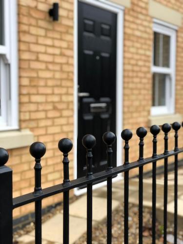 a black door on a house with a fence at The Martins in Peterborough
