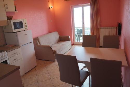 a kitchen and living room with a table and a refrigerator at Guest house Ivo in Lovran