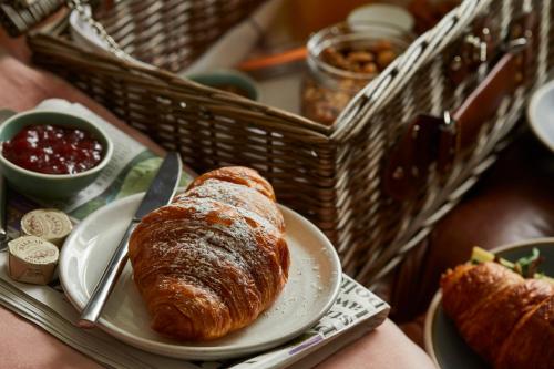 a plate with a loaf of bread on a table with a basket at Broad Street Townhouse in Bath