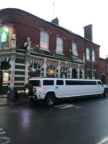 una limusina blanca estacionada frente a un edificio en Shanahans B&B with Sports Bar, en Birmingham