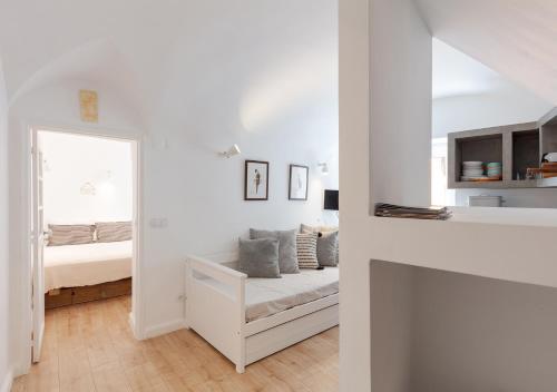 ein weißes Zimmer mit einem Bett und einem Fenster in der Unterkunft Studio Hideaway- in a Traditional Neighborhood in Lissabon