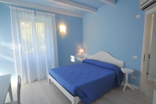a blue bedroom with a bed with a blue blanket at Villa Carolina in Domaso
