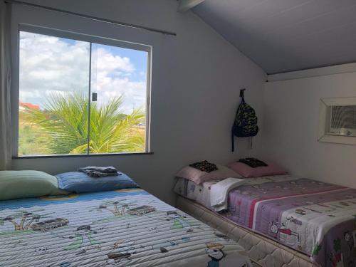 - 2 lits dans une chambre avec fenêtre dans l'établissement Casa no Atalaia, à Salinópolis