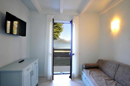 a living room with a couch and a sliding glass door at Villa Carolina in Domaso