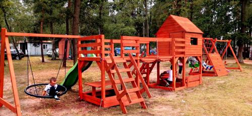 a childrens playground with a wooden play structure at POLICYJNY OŚRODEK WYPOCZYNKOWY in Niesulice