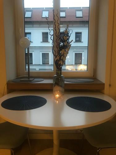a table with a vase on it in front of a window at VULTOR Apartments in Wrocław