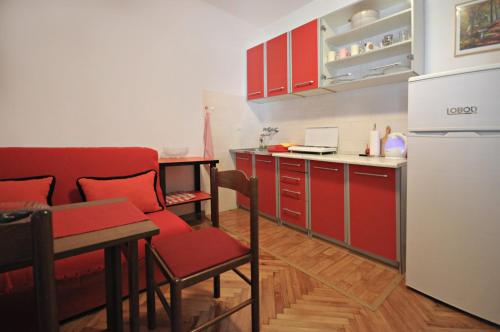 a kitchen with red cabinets and a white refrigerator at Apartments Nada in Budva