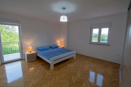 um quarto com uma cama e duas janelas em Apartman Vitina em Ljubuski